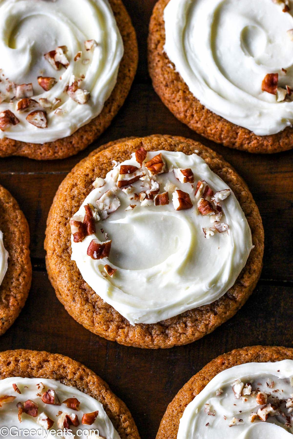 Easy and chewy on the edges Carrot Cake Cookies topped with cream cheese frosting and chopped nuts.