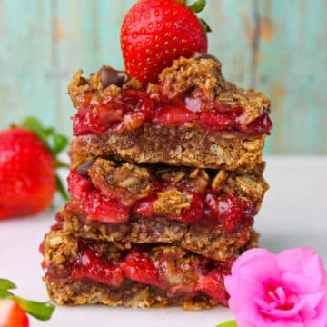 A stack of chewy Strawberry Oatmeal Bars layers with fresh strawberry filling.