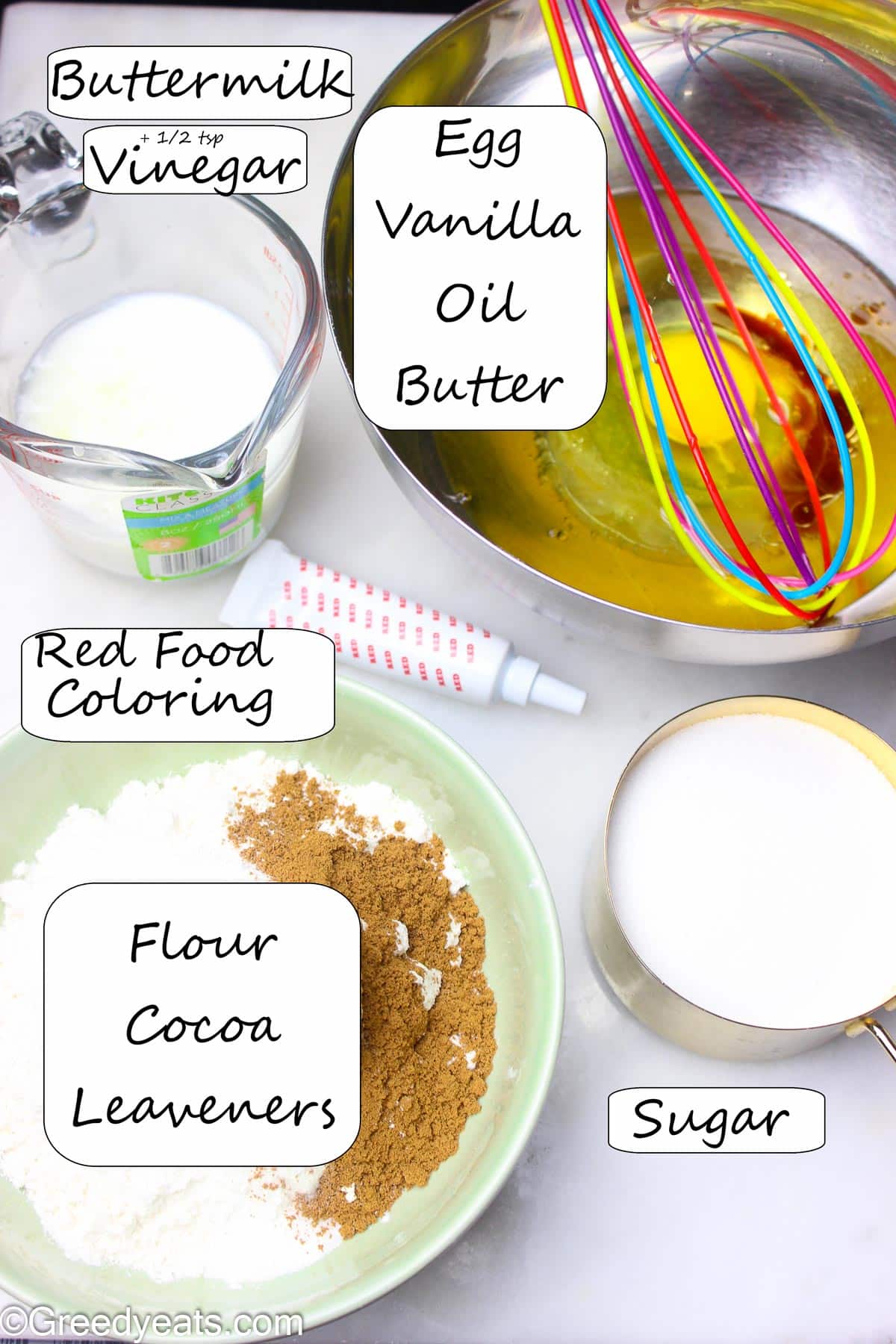 Ingredients like egg, cocoa, flour, sugar, butter, oil and food coloring for cupcakes.