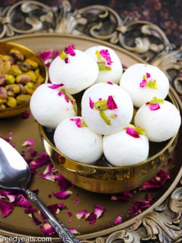Soft and fluffy Rasulla soaked in sweet rose syrup garnished with slivered pistachios and rose petals.