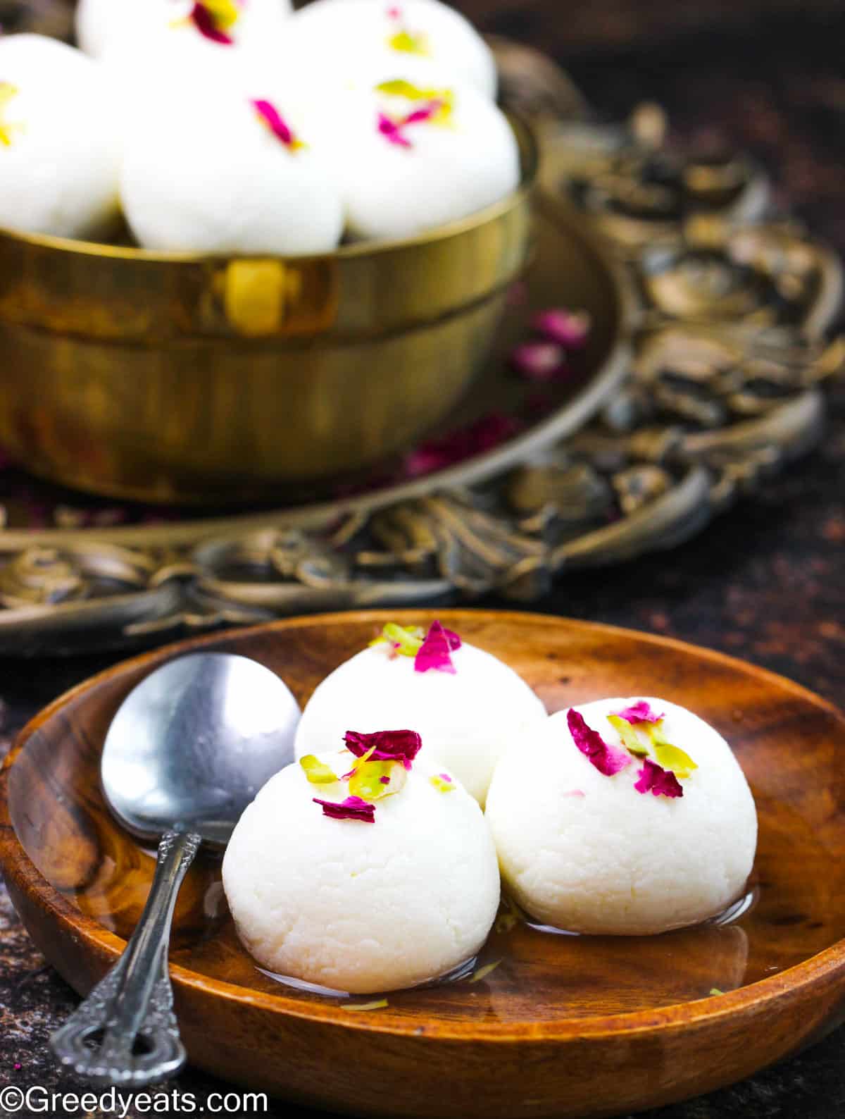 Soft and sweet rasgullas served in sugar syrup flavored with rose and garnished with pistachios.