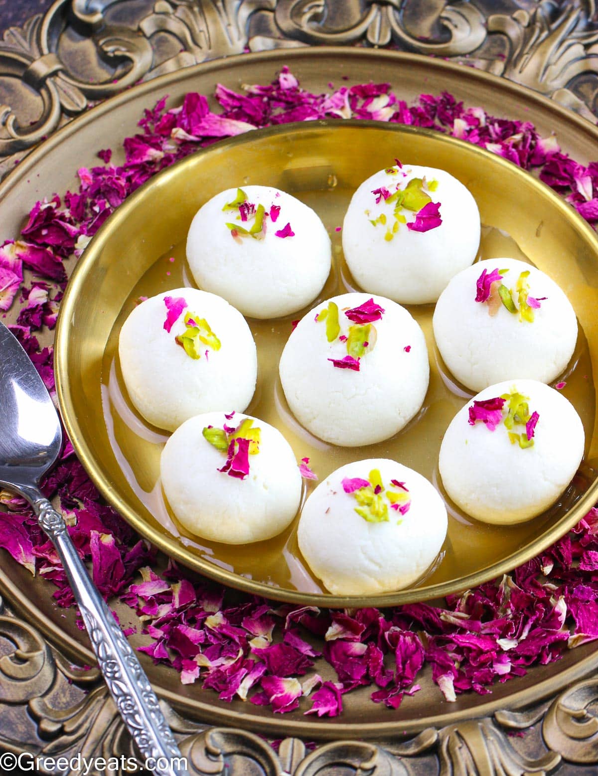 Easy Rasgulla recipe that yields soft and spongy rasgullas that are served in syrup a bronze plate