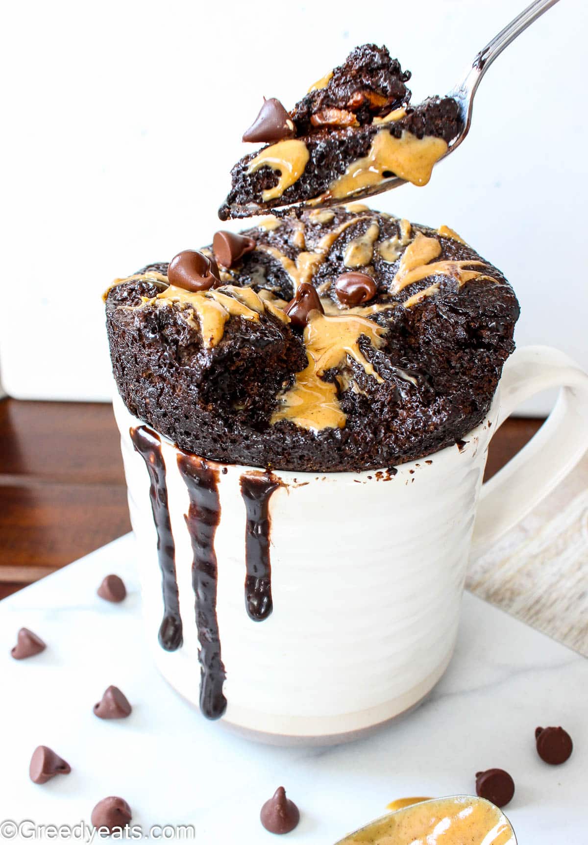 Moist and soft Peanut butter and chocolate mug cake topped with more peanut butter and chocolate chips