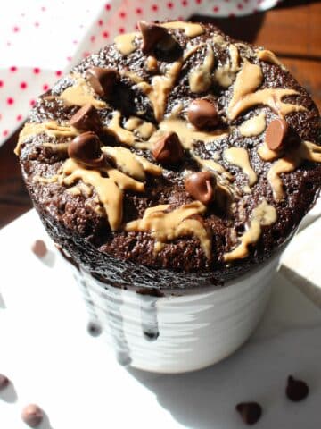 peanut butter Mug Cake with a dollop of peanut butter and topped with chocolate chips.