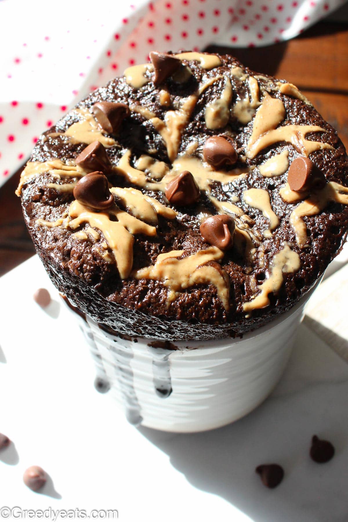peanut butter Mug Cake with a dollop of peanut butter and topped with chocolate chips.