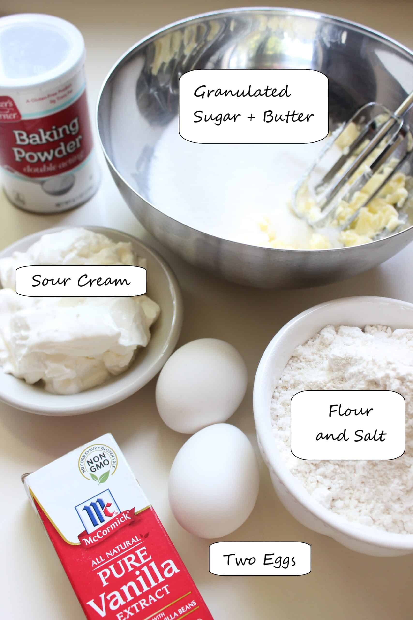 Ingredients like flour, sugar, vanilla, eggs and butter needed to make vanilla cupcakes.
