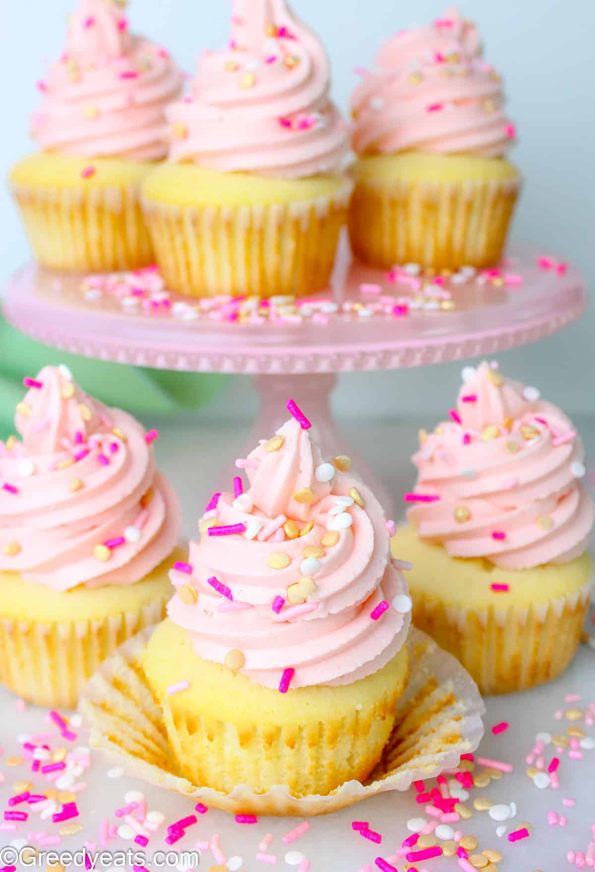 Moist Vanilla Cupcakes topped with a soft and perfect vanilla buttercream with pink sprinkles on top.
